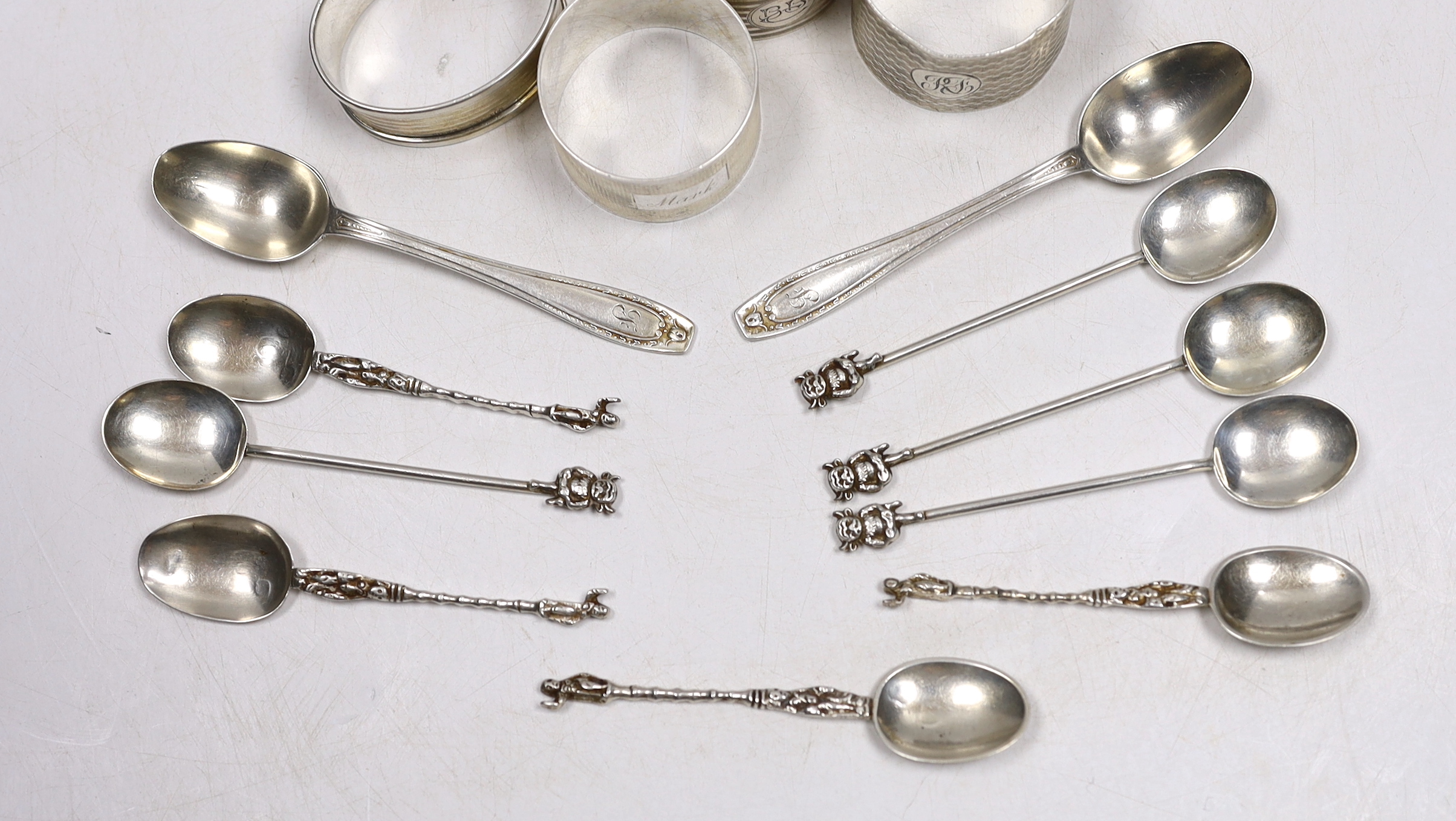 Four assorted silver napkin rings, six assorted silver coffee spoons including four with 'imp' terminals and four continental white metal coffee spoons.
